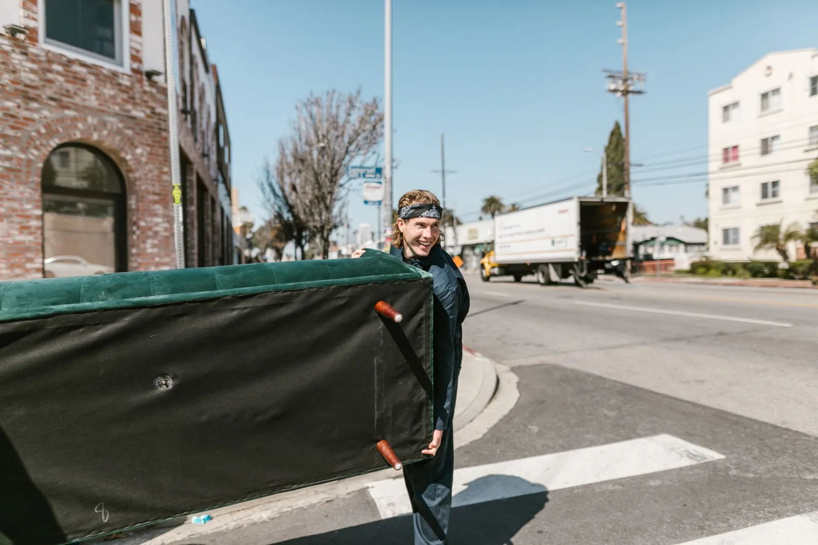 Crew carrying an old couch out of a Gainesville FL apartment for removal